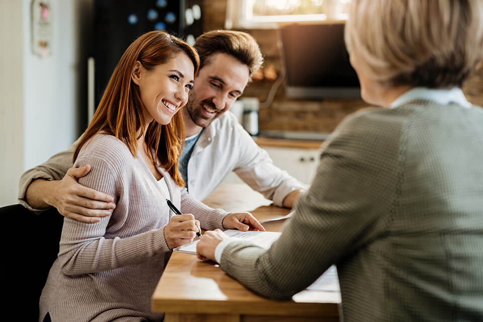 young-happy-woman-her-husband-signing-agreement-with-insurance-agent-during-meeting (1)